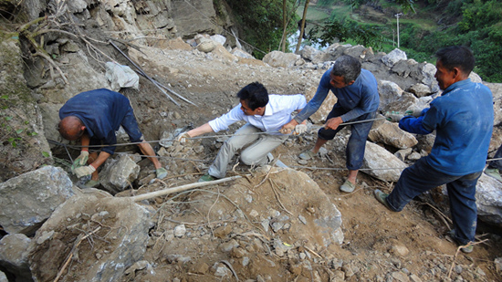 图为张明富在公路工地上和村民布钢筋