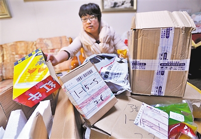 昨日,渝北区黄泥塝,张女士在楼道找到一堆被偷拿的快递包裹,有自己的也有邻居的。包裹已经被打开,有些东西被拿走。 重庆晨报记者 甘侠义 实习生 龚湛 摄