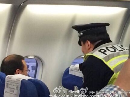 图片说明：网友拍摄的民警上机带走男子图。微博网友图