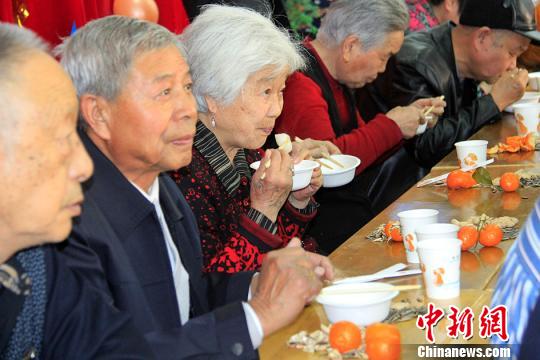 居民边吃汤圆边看节目。　曹新加　摄
