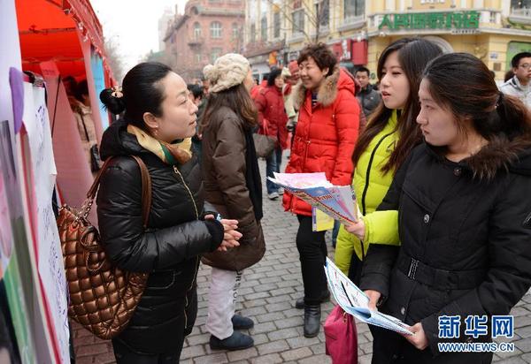 3月8日，几名女性求职者在哈尔滨妇女专场招聘会上向企业咨询。新华社记者 马晓成 摄
