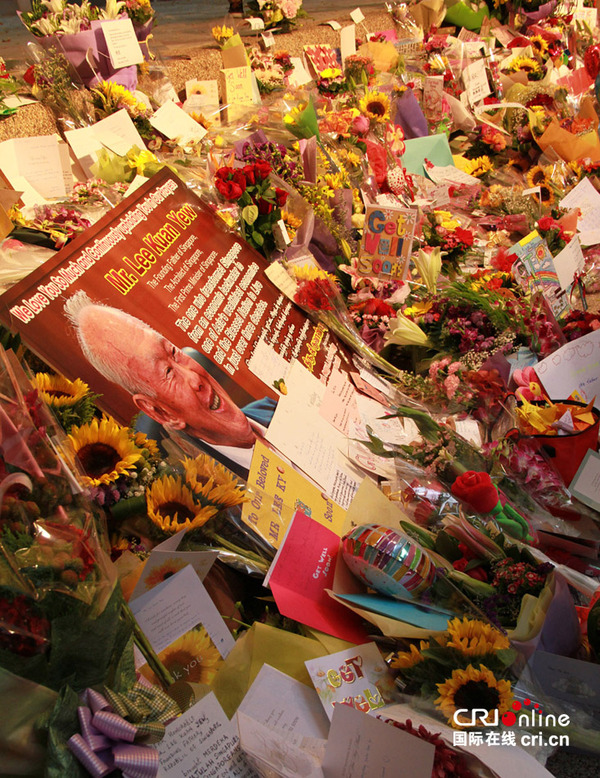 身穿马来传统服装和华族传统服装的卡通人物手牵手，感谢李光耀为新加坡所做的贡献