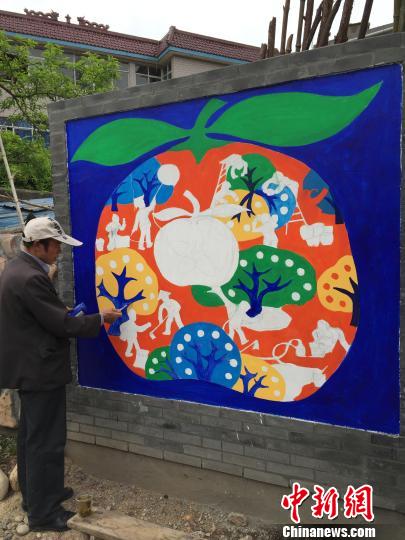 农民画家郑位良创作《桔乡风采》　吴雨辰　摄