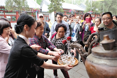 工作人员现场沏茶，游客争相品尝。新京报记者 薛珺 摄