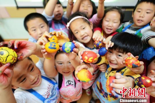 图为幼儿园的小朋友展示自己手绘的七彩斗蛋。 孟德龙 摄 中新网南京5月6日电(记者 崔佳明)5月6日是二十四节气中的立夏,扬州民间有斗蛋绘彩蛋称人等多种习俗。当日,江苏扬州市杉湾花园社区杉湾幼儿园的小朋友手绘七彩斗蛋,体味民间习俗。 扬州民俗专家黄老师讲述了扬州立夏的习俗,他说,斗蛋是说,立夏当日,家家户户煮好带壳鸡蛋,不能破损,用冷水浸上数分钟之后再套上早已编织好的丝网袋,挂于孩子颈上。孩子们便三五成群,进行斗蛋游戏。蛋分两端,尖者为头,圆者为尾。斗蛋时蛋头斗蛋头,蛋尾