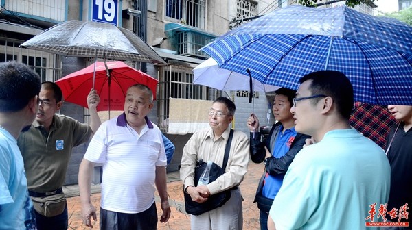 “老长沙”何嗲（穿白色T恤者）向志愿者介绍万人冢的情况。