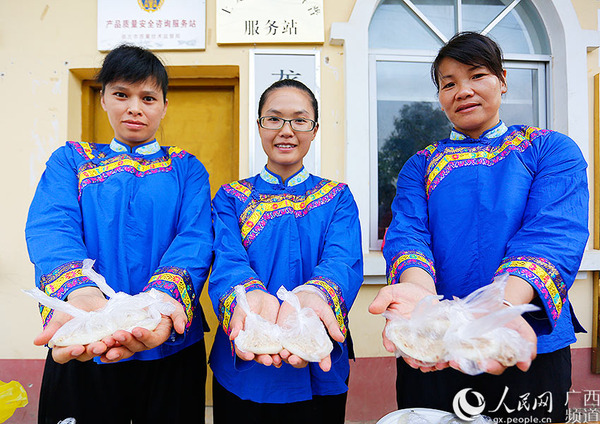 走上小康路的弄农屯村民向记者展示当地特色美食“手工糍粑”