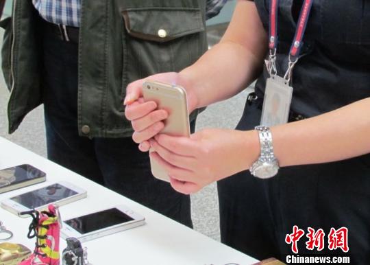 图为安检人员检查到的“iPhone”打火机　钟欣　摄