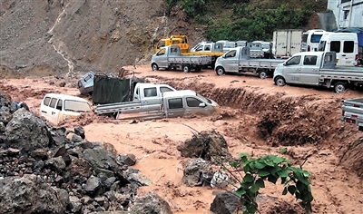 昨日，巫山县突降暴雨，一家车行几辆新车被洪水冲走。重庆晨报记者 雷键 通讯员 谭冰心 摄