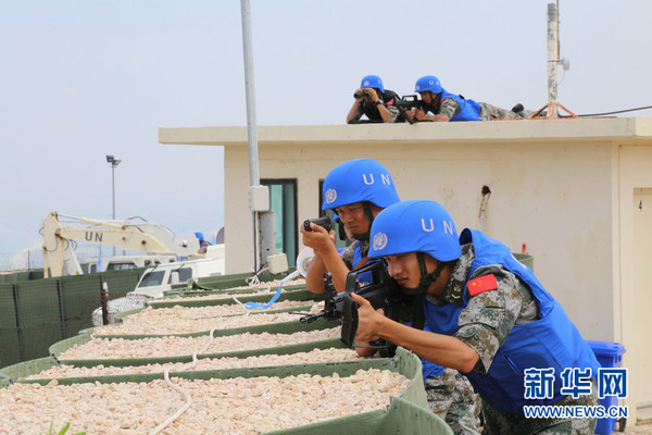 中国维和官兵们迅猛出击，快速占领有利地势，对恐怖分子形成火力合围。（王永安摄）