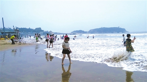 昨日上午正值涨潮,南澳海滩风不大,但海浪汹涌,不少游客仍在海滩上玩耍