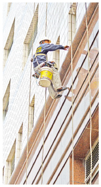 图为一名高空作业工人在北京一栋大楼外立面工作。赵丽　摄