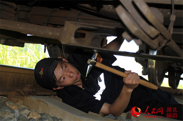 检车员多看一眼，认真检查车辆底部交叉杆盖状况。（刘卫兵 摄）