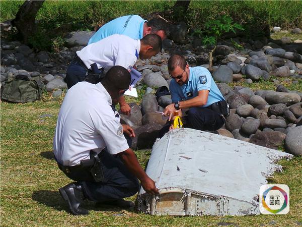 　　图为7月29日，在法属留尼汪岛，警察查看一块飞机残骸。 新华/路透