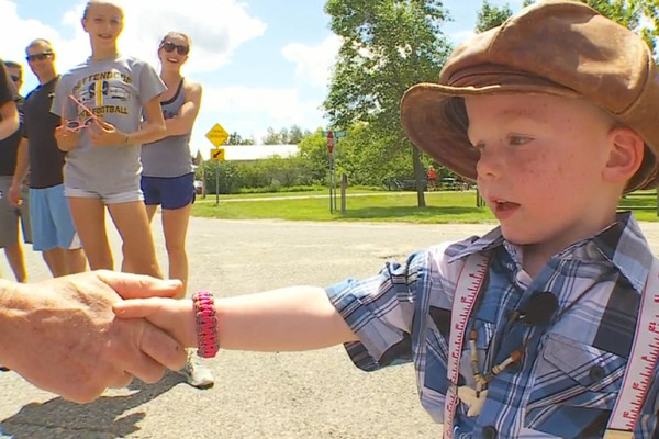 3岁的小镇长和受自己管辖的居民握手（网页截图）