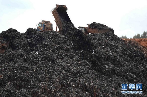 　　作业车辆在南宁市城南垃圾填埋场铺平垃圾（8月14日摄）。