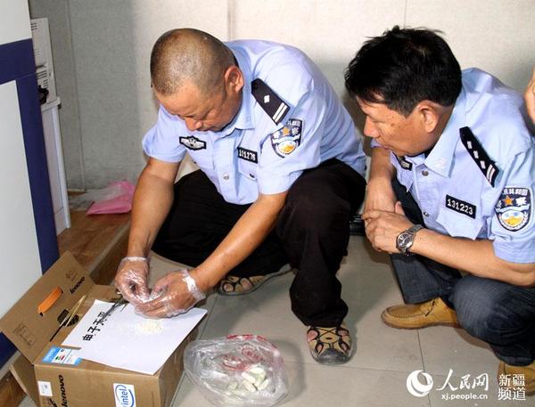哈密铁路公安处刑事技术人员对查获的毒品海洛因拆封。