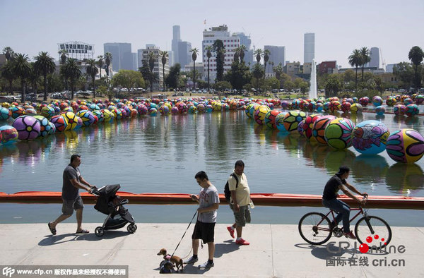 当地时间2015年8月23日,美国洛杉矶,当地麦克阿瑟公园的湖面被放置了许多彩色充气球。据悉,这些装置是“希望的肖像”项目的一部分,旨在通过鼓励社区参与推广艺术作品。图片来源:CFP