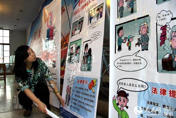 剧目开演前，唐应欣律师检查普法宣传栏的安置情况。（朱虹 摄）