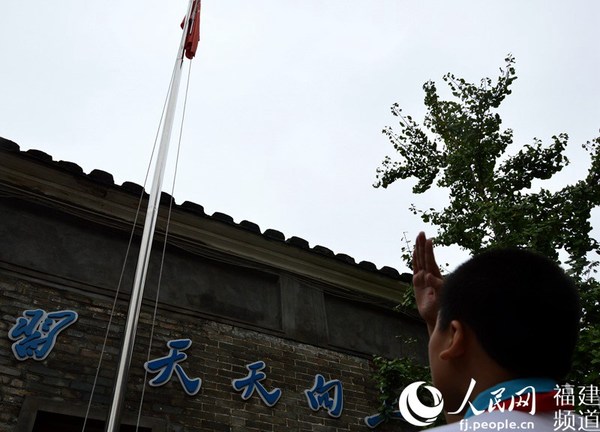 福州市仓山区第二中心小学新学期第一天的升国旗仪式上，国旗下的一名小护旗手行少先队队礼。李挺摄