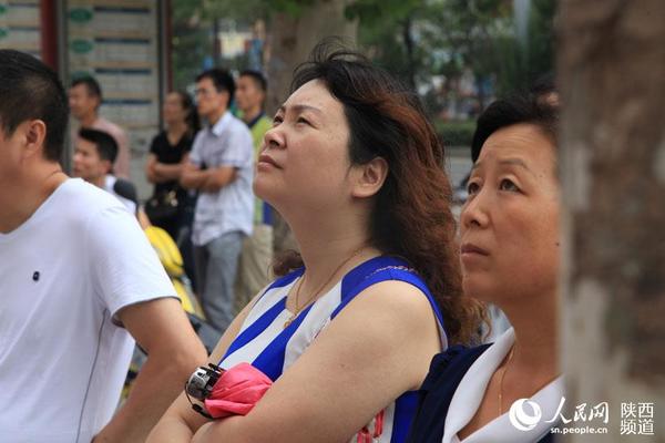 路过市民停下脚步观看阅兵。杜旭涛 摄