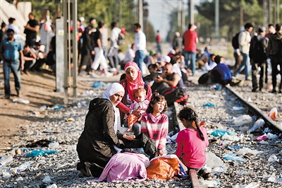 9月5日,在希腊边境的一个火车站,难民们等待进入马其顿。 新华社发