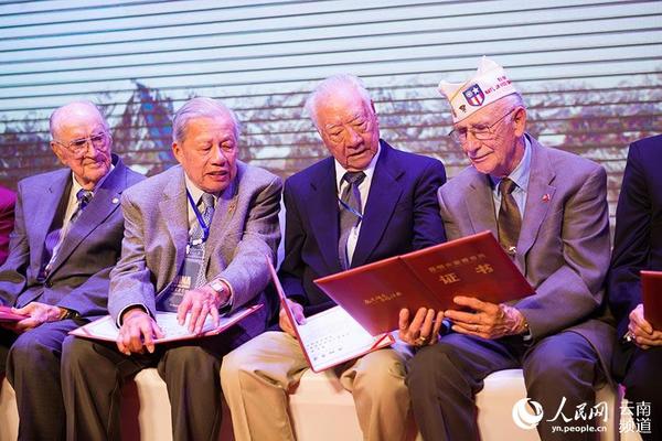 几名老兵在阅读“昆明市荣誉市民”证书上的内容。（人民网 李发兴  摄）