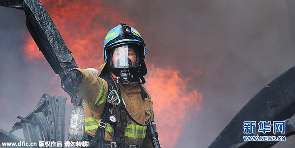 当地时间2015年9月11日，韩国安山，一工业园区内的胶片厂发生火灾，现场浓烟滚滚，消防员奋力扑救。图片来源:东方IC