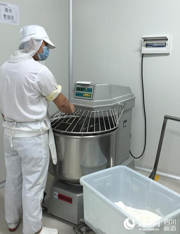 第一步，将面粉搅拌均匀，制作成月饼皮。（段秀 摄）