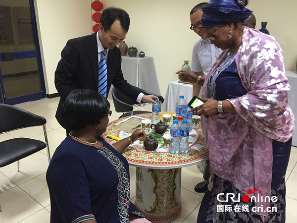 中北矿业有限公司董事长张文东（左二）向尼日利亚旅游文化部常秘等嘉宾介绍中国瓷器。（摄影：张威伟）