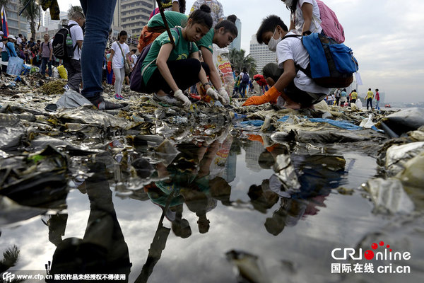 　　当地时间2015年9月19日，菲律宾马尼拉，国际海滩清洁日当天，政府雇员和学生组成志愿者队前往马尼拉湾海岸线清理垃圾。图片来源：CFP