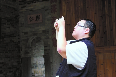 ?台湾诗人宋尚纬在土楼里拍照采风。