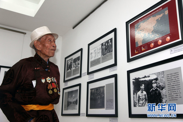 ２１日，９７岁的蒙古国参加抗日战争老兵亚达玛道尔吉在观看纪念中国人民抗日战争胜利７０周年图片展中的图片。新华社记者郑闯 摄