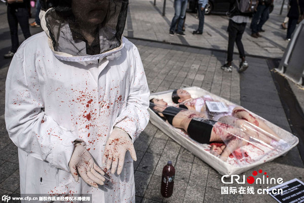 当地时间2015年9月26日,法国里昂动物保护者在一个屠宰场举行示威活动,身体上泼洒代表血迹的红色油漆,增强人们对于动物解放的重视。图片来源:CFP