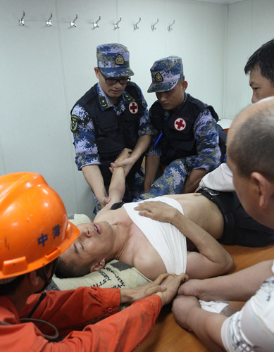 随舰骨科医师易红蕾与军医杨光涛在福全山号对邓坚明进行救治。侯融摄