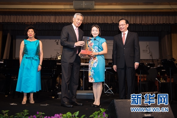 图为10月9日晚宴现场，新加坡总理李显龙（左二）向捐款机构代表之一、中国银行新加坡分行行长郭宁宁（右二）颁发纪念品。（王应耀 摄）