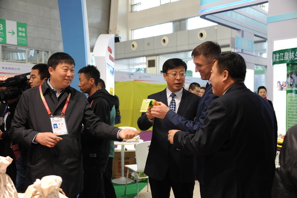 同江市委书记隋洪波（右三）、市长王金（左一）向俄犹太自治州列宁区区长瓦列里介绍同江参加博览会的绿色农产品。李鑫摄