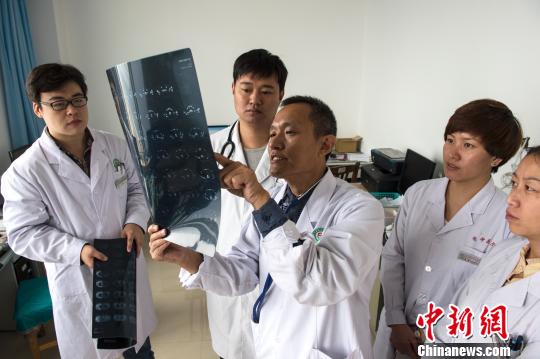 图为韩文宝坚持每天插着腹腔“T管”坐诊、查房、会诊，每天口服6种药物控制疾病。　陈儒 摄