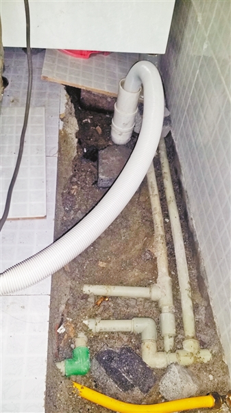 谢女士家洗衣槽处挖开了地砖。