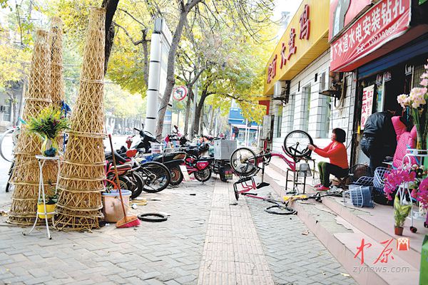 东明路上,商户突出店外经营 中原网讯(记者 王军方 文/图) 市民致电本报热线,投诉东明路商户突出店面经营情况较严重。 昨日中午,记者在政四街和东明路口西南角人行道上看到,一家水果店将自家三轮车停在路上兜售。路口北边,一家经营轮胎的商户将很多轮胎摞在一起放在人行道上。路口南边,一鲜花店将高2米左右的花篮放在人行道上。金水路至红专路的东明路上,除了这家鲜花店外,至少还有3家鲜花店将花篮摆放在店外。 一家烟酒店在门口将成箱的酒摆放在一起促销。记者数了数,至少有100多箱。 既然有店面,为什么非要将商品摆放在