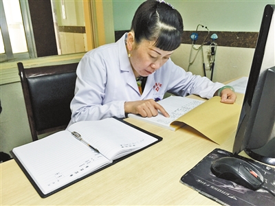 谭琼兰在审查医院的开支清单。本报记者 王鑫 摄