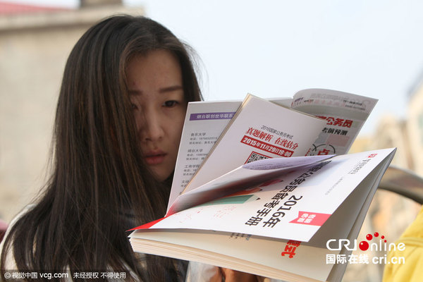 　　2015年11月29日，山东省烟台市，考生在南通路小学考点门前临阵复习。图片作者:凤尾竹/视觉中国