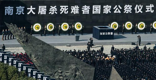 2014年12月13日，礼兵在南京大屠杀死难者国家公祭仪式上将花圈安放在“灾难墙”前。