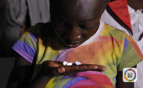 11月9日，一名13岁肯尼亚少女正在吃药。她是艾滋病患者，父母因病双亡，与祖母相依为命。（图片来源：新华／法新）
