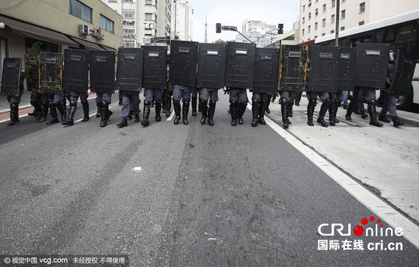 　　当地时间2015年12月4日，巴西圣保罗学生抗议州政府进行学校重组，警方使用催泪弹驱散抗议者。图片来源：视觉中国