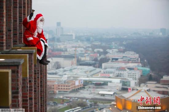 资料图：身穿圣诞老人服饰的男子爬上百米高楼。