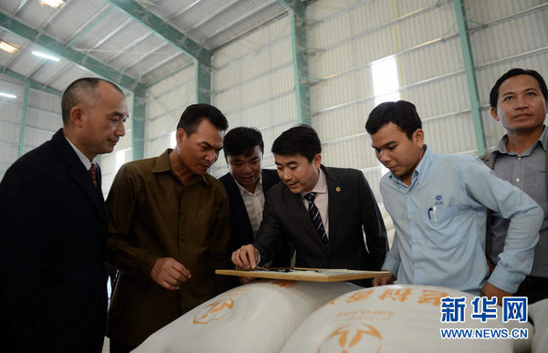 12月10日，在老挝沙湾拿吉省，嘉宾在查看即将出口中国的老挝大米。新华社发（刘艾伦摄）