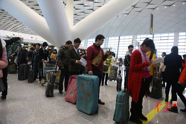 “乘客”正在排队办理登机手续。