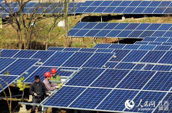 工人在遂川太阳能光伏发电站施工现场安装光伏电池板