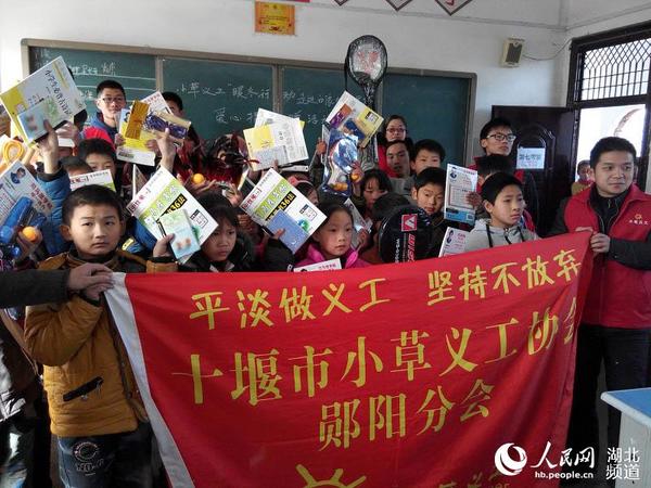 小草义工志愿者和孩子们一起合影 人民网十堰12月19日电 12月18日,湖北省十堰市小草义工协会郧阳分会的志愿者们走进该区最偏远的白浪镇九年一贯制学校,为这里的31名家庭特别贫困的留守儿童送来了学习用品和过冬衣物,助他们过暖冬。 当天,小草义工的志愿者们早晨六点多就从家里出发了,冒着冬日的凌冽寒风,长途跋涉6个多小时,一路颠簸来到该校。 当小草义工志愿者把捐赠的学习用品和过冬衣物递到学生手里时,孙保军同学高兴地说:谢谢您!叔叔!这衣服很好,我喜欢。孙保军同学由于父亲患有食道癌,家里因病致贫,负债累累,